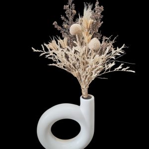 White ceramic loop vase with a neutral preserved dried flower arrangement